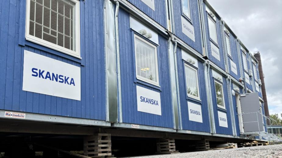Fasaden på en bodetablering med blå bodar i två våningar märkta med Skanska-skyltar.